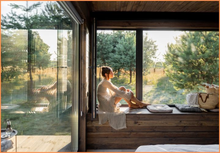 Woman relaxing in a rural Georgia home with scenic views, representing USDA loan options in Cobb County, GA